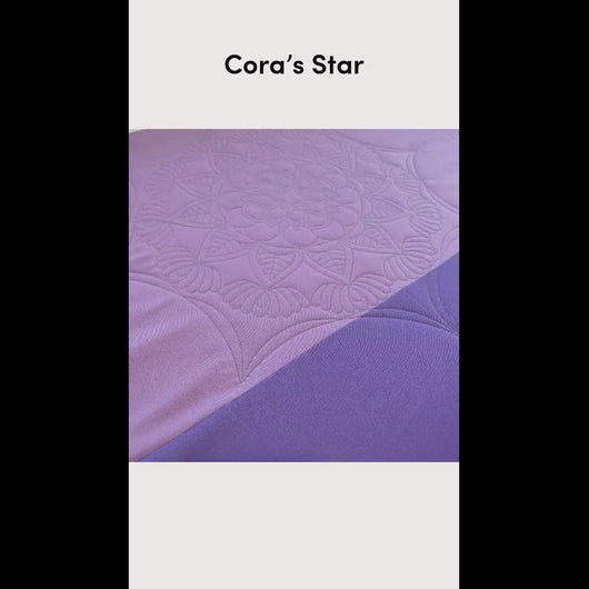 Short video showing a time lapse of the design being stitched out on a purple solid-colored background.